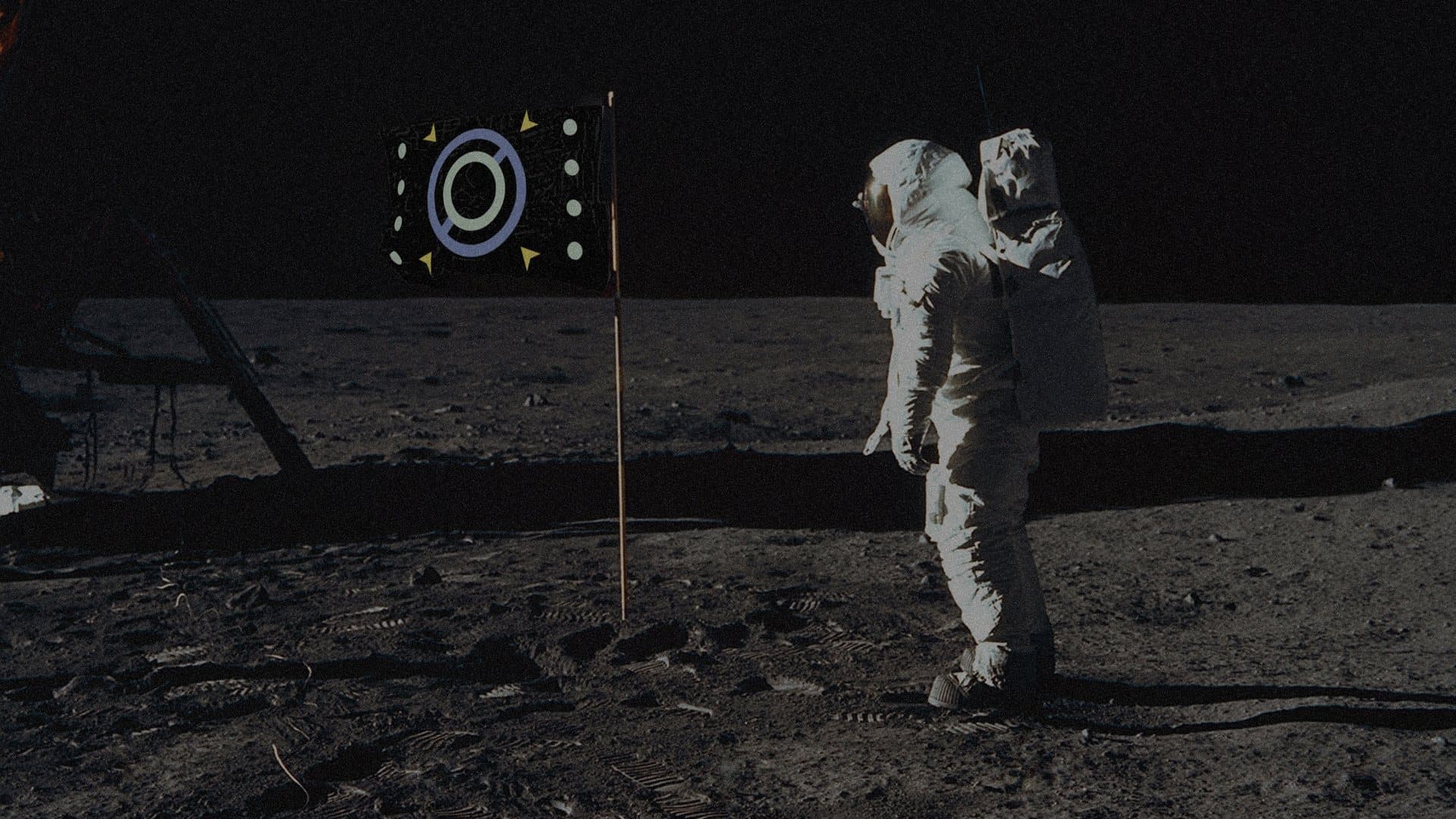 the flag planted on the lunar surface beside an astronaut, from the Apollo photograph